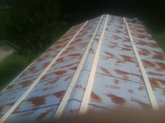 Rusted metal roof panels with new wood purlins before replacement — Storm Damage Roof Repair in Rayland by Roofing Brothers