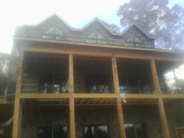 Dormers and porch framing on a large log home under construction — Roof Coating work by our crew in Rayland