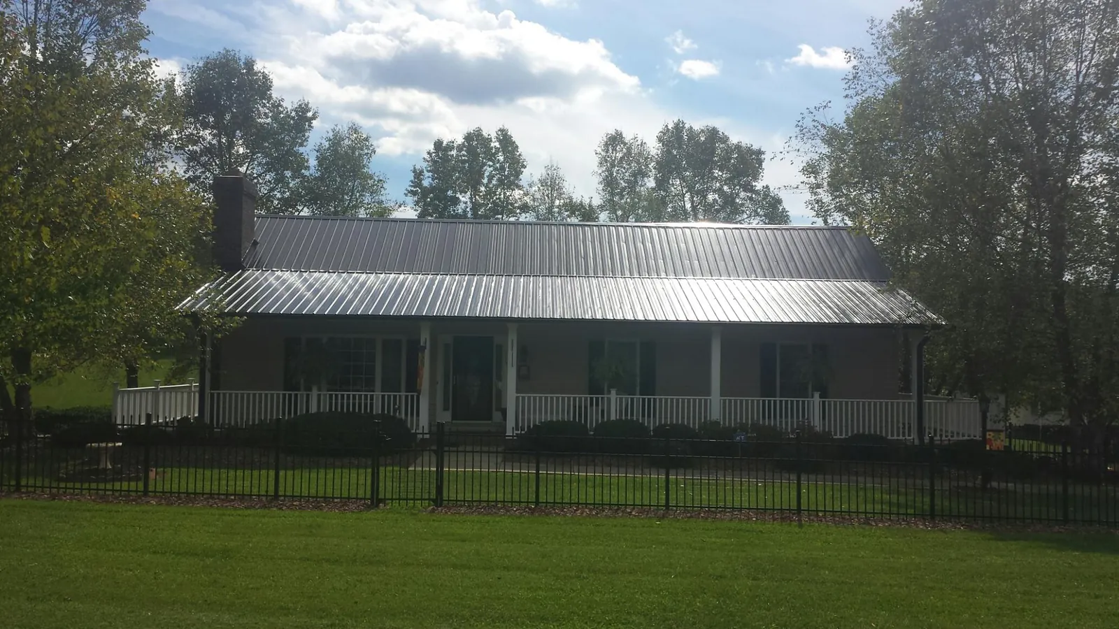 Gray metal roof on a brick ranch with a full width front porch — Gutter Guard Installation work by our crew in Rayland