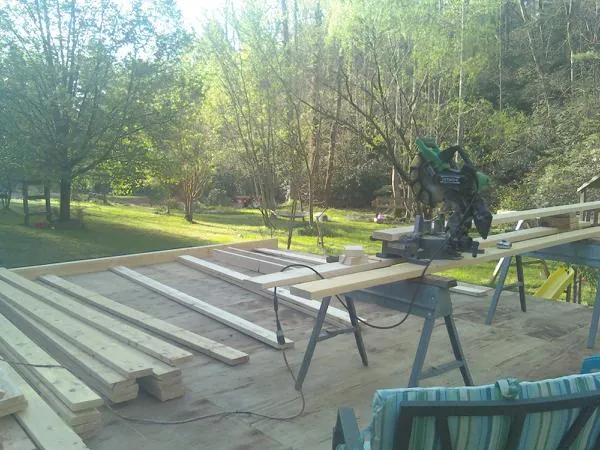 Miter saw and framing lumber on a deck under construction in Rayland