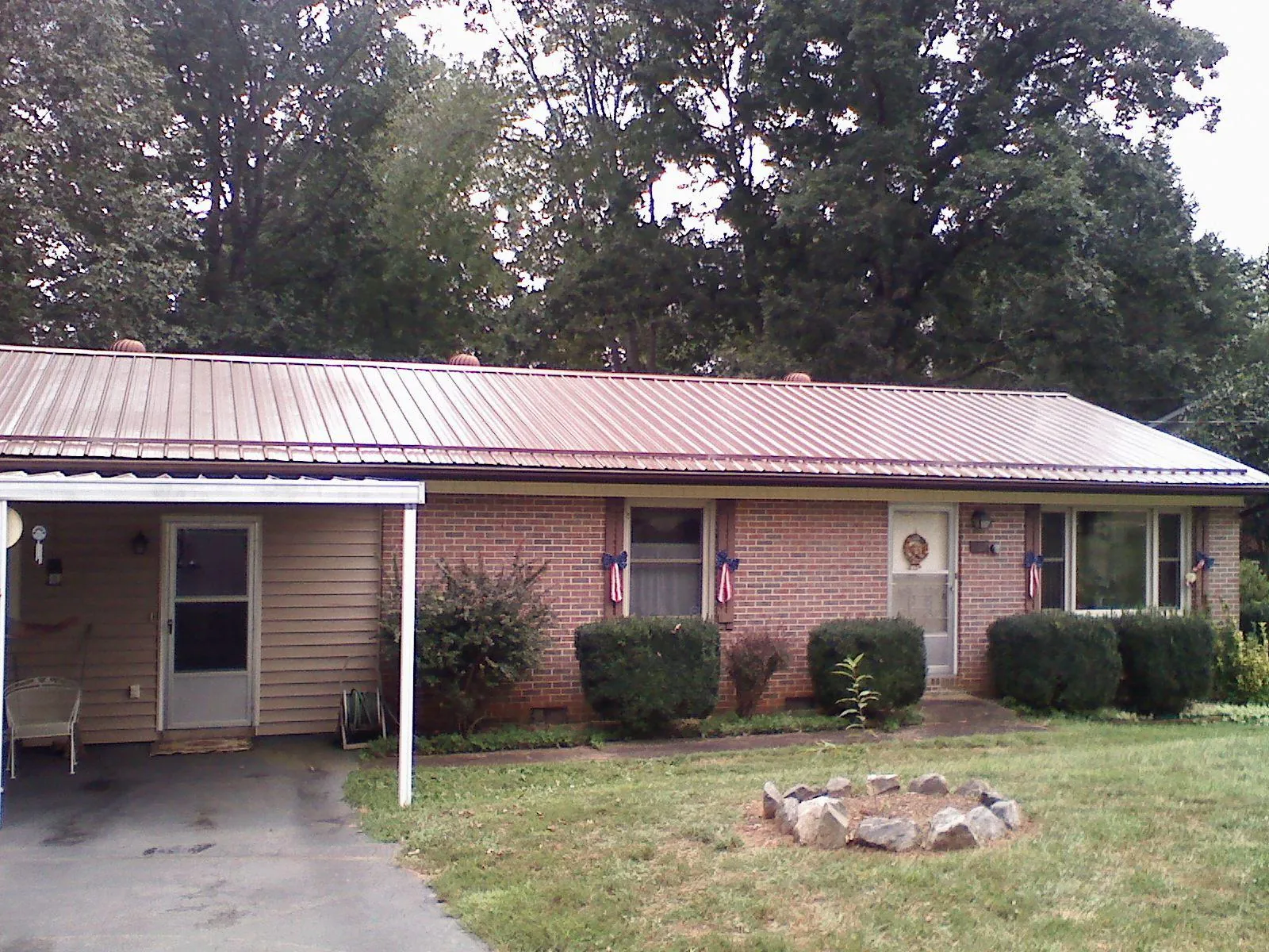 Bronze metal roof and carport on a brick ranch home — Roof Repair work by our crew in Rayland